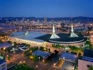 Aerial night view of Portland cityscape with the illuminated Oregon Convention Center, capturing its distinctive twin spires.