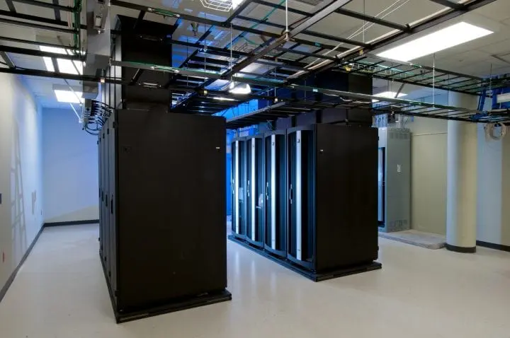 Modern data center interior with black server racks and cabling, showcasing high-tech infrastructure.