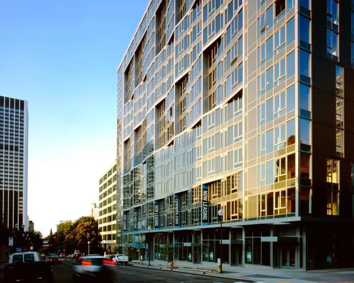 Modern city building at sunset with glass facade, capturing urban life and architecture.