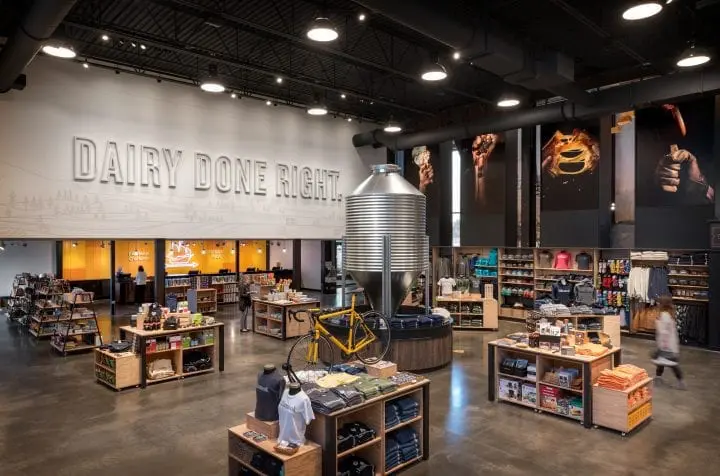 Modern dairy store interior with merchandise displays, industrial decor, and Dairy Done Right slogan on the wall.