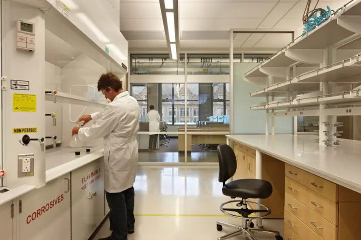 Scientist conducting experiments in a modern laboratory setting, surrounded by equipment and supplies.